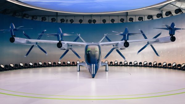 Protótipo de aeronave elétrica de pouso e decolagem vertical, com hélices, exposto em ambiente interno