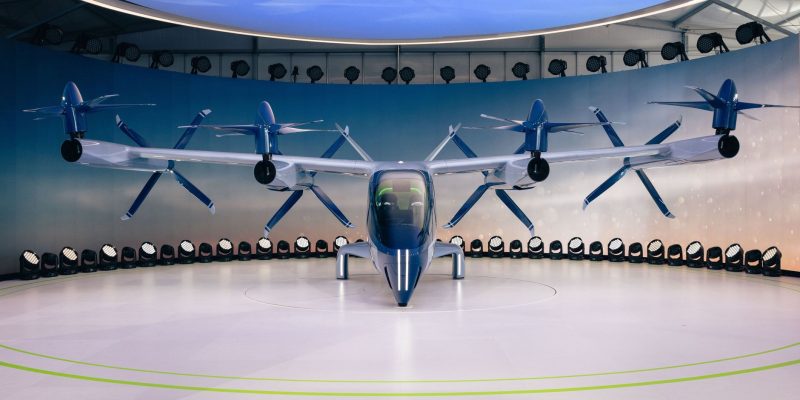 Protótipo de aeronave elétrica de pouso e decolagem vertical, com hélices, exposto em ambiente interno