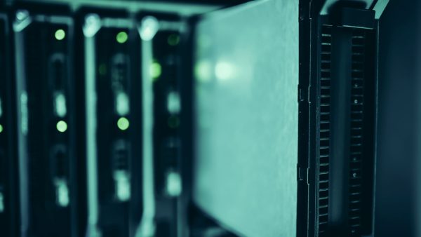Racks de servidores iluminados em azul dentro de um moderno datacenter.
