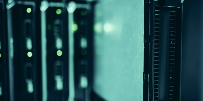 Racks de servidores iluminados em azul dentro de um moderno datacenter.