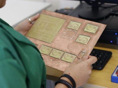 Técnico examina uma placa de circuito em um laboratório de eletrônica.
