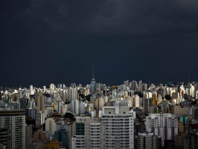 Vista do horizonte urbano de São Paulo sob nuvens escuras de tempestade.