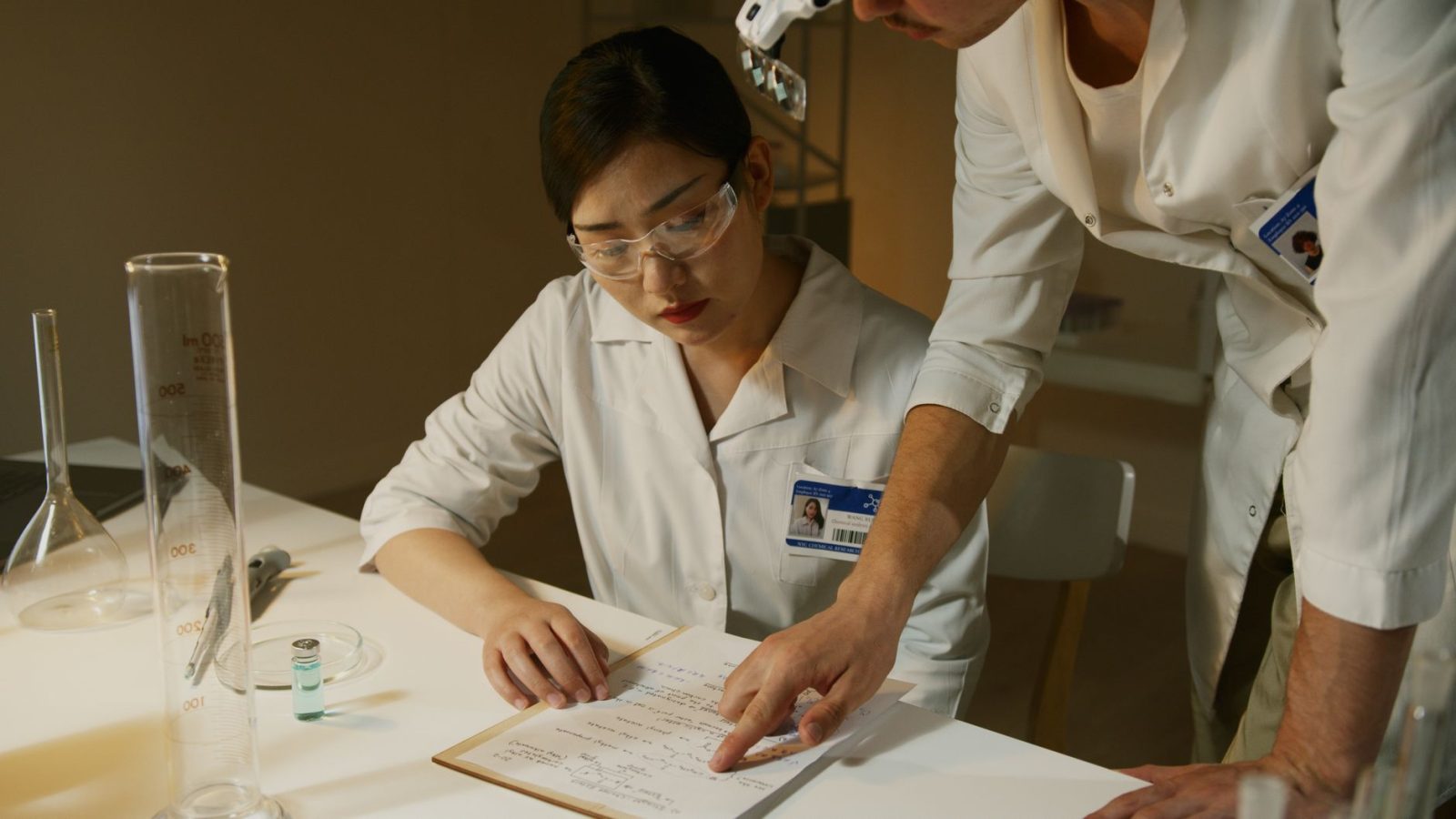 Pesquisadores de jaleco analisam anotações durante um estudo científico em laboratório.