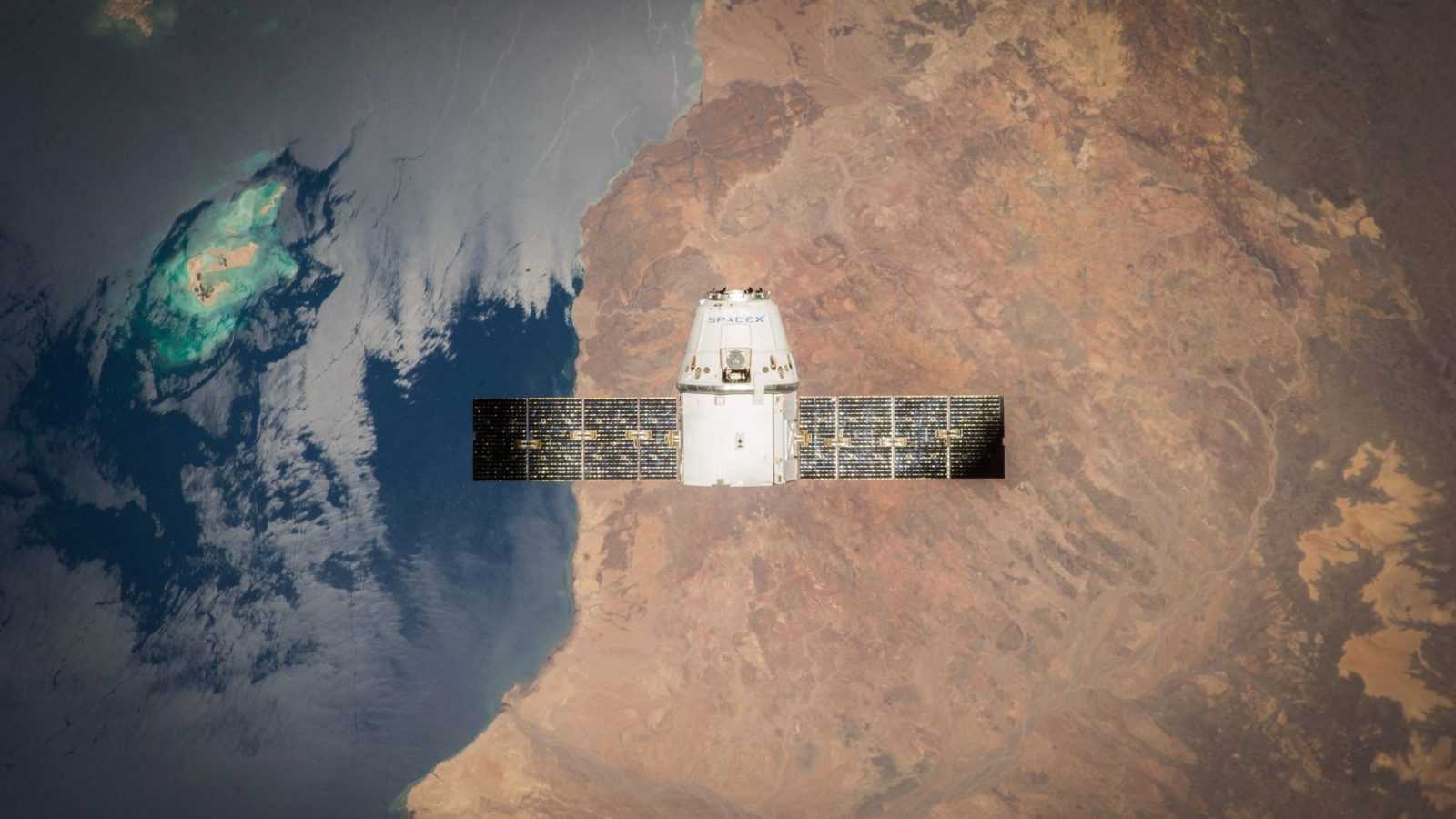 Satélite em órbita sobre a Terra, com o oceano e parte do planeta visíveis ao fundo