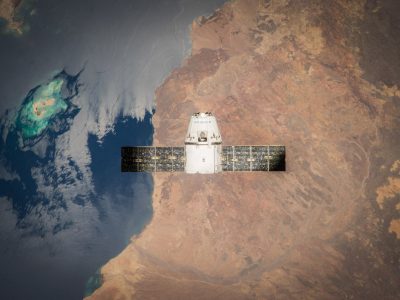 Satélite em órbita sobre a Terra, com o oceano e parte do planeta visíveis ao fundo